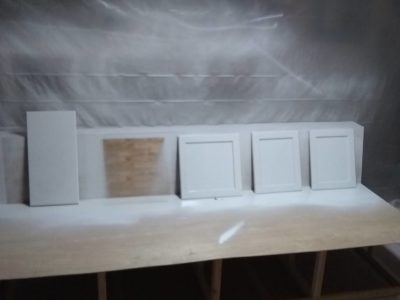 Priming process of a cabinet paint job. These are the drawer faces and doors.